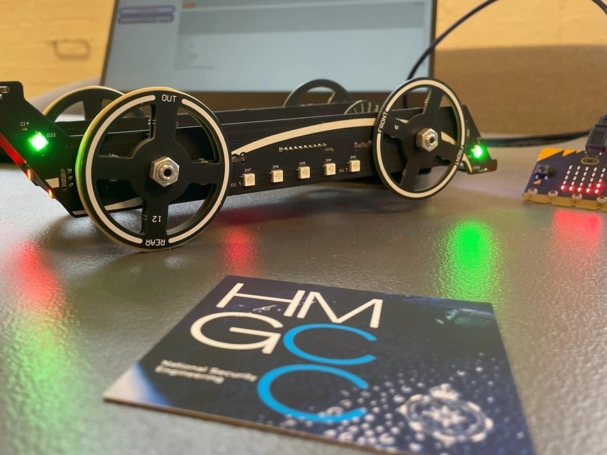 A model car on a desk, plugged into a microchip