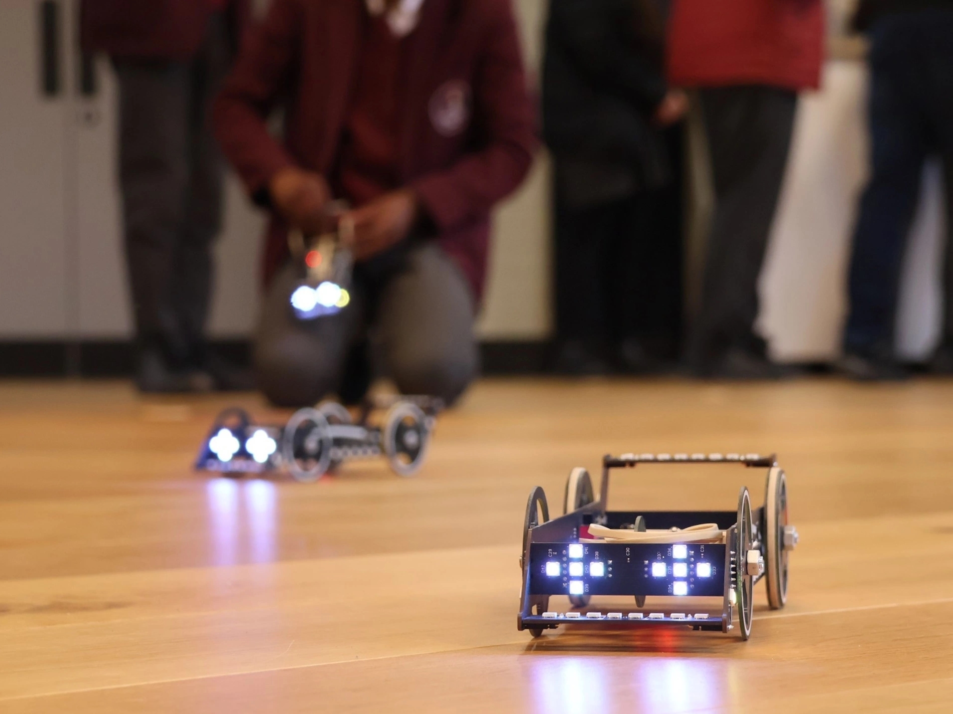 Engineered cars in the foreground, students in uniform in the background